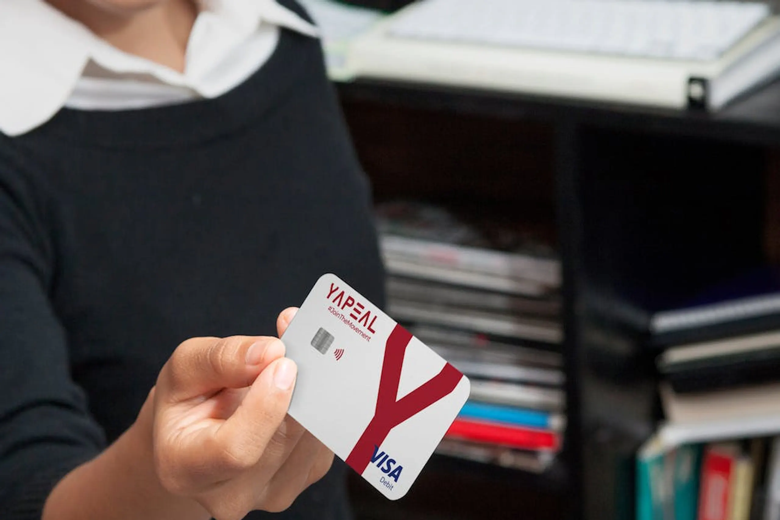 Foto Frau hält YAPEAL Kreditkarte Visa in die Kamera