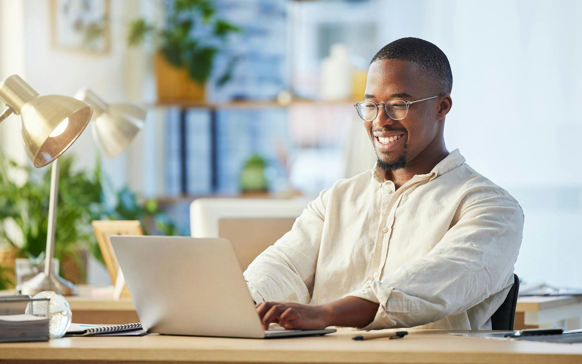 A smiling business man working on a laptop.