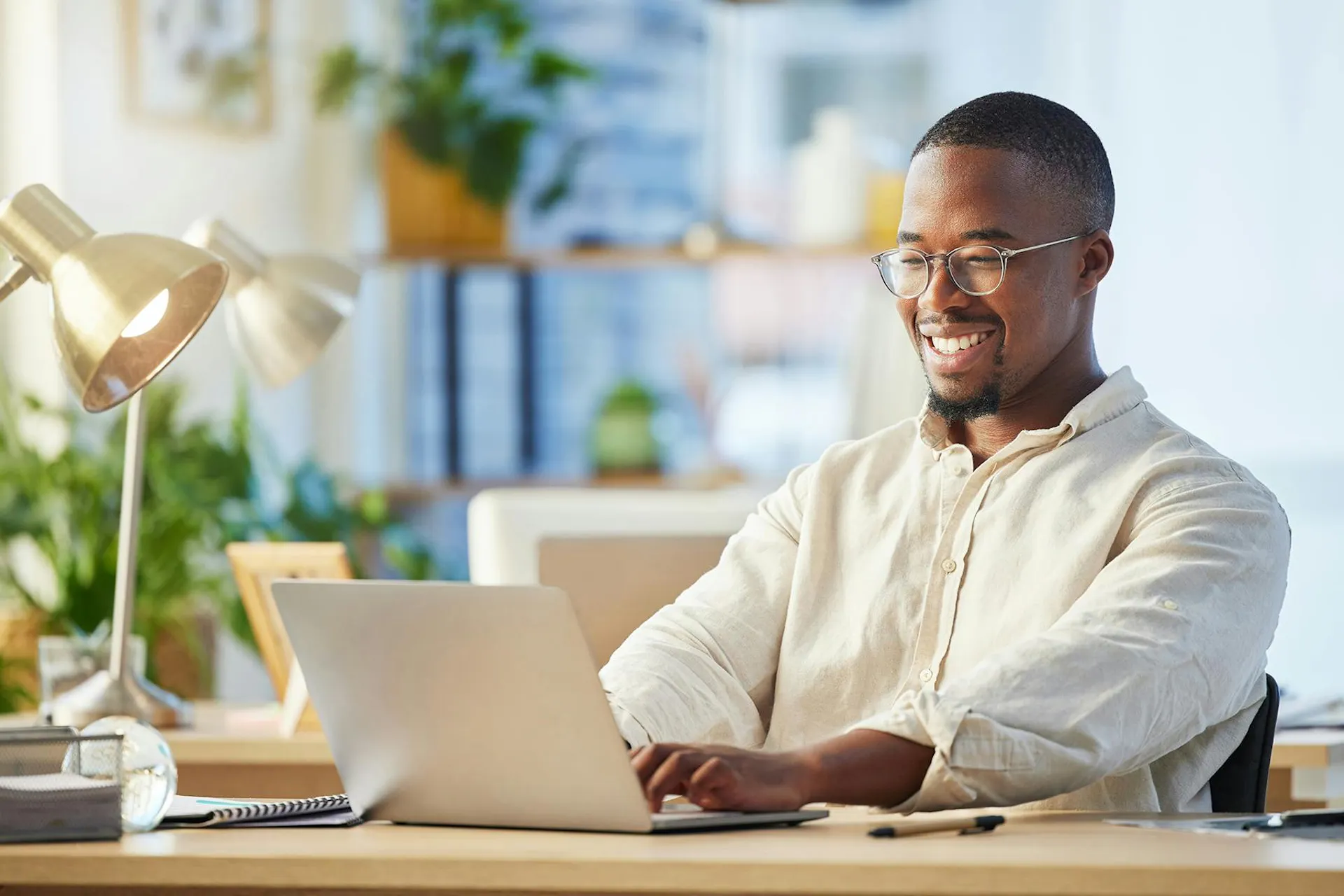 A smiling business man working on a laptop.
