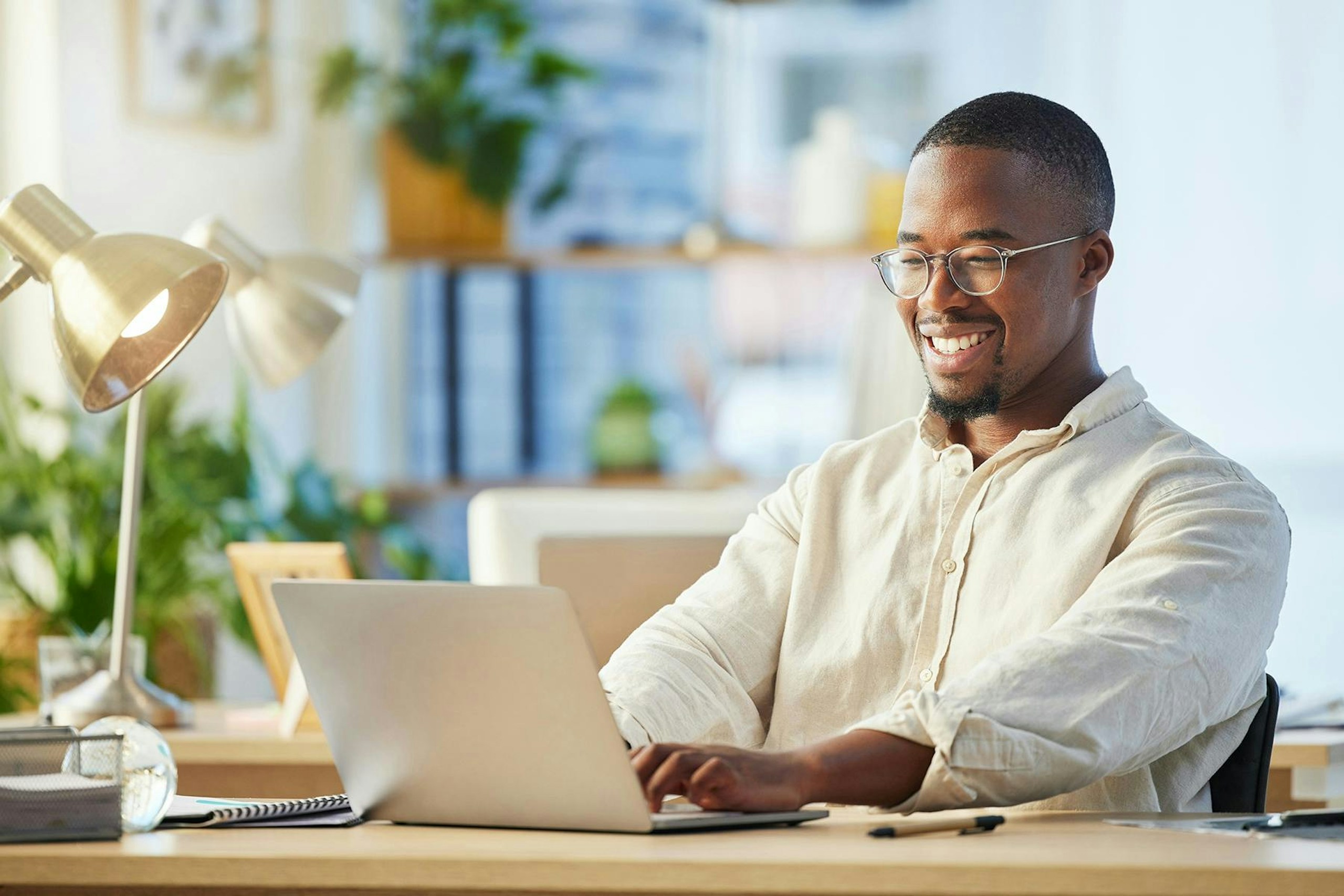 A smiling business man working on a laptop.