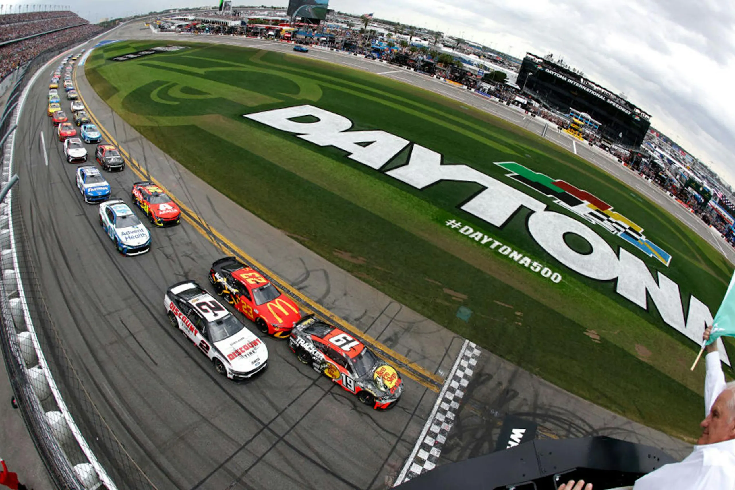 A fish eye lens photo of stock cars racing in the Daytona 500.