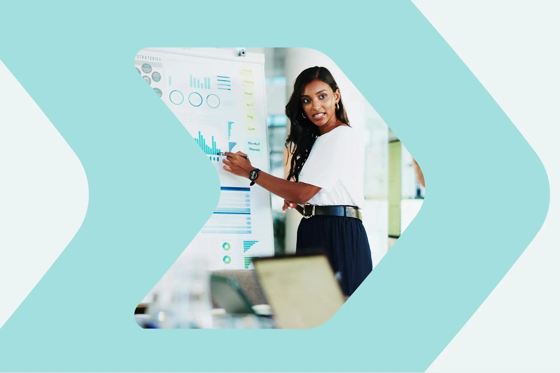 A woman standing at a whiteboard giving a presentation with results of media monitoring for a large organization. Ultimate Guide to Media Monitoring ebook.