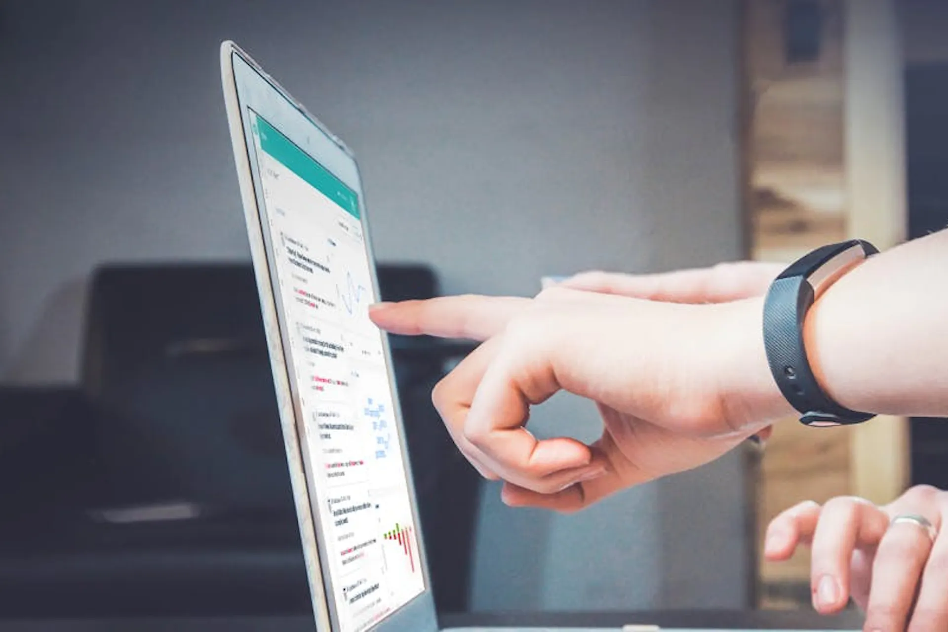 Photo of people pointing at a screen with the Meltwater Media Intelligence Platform on it