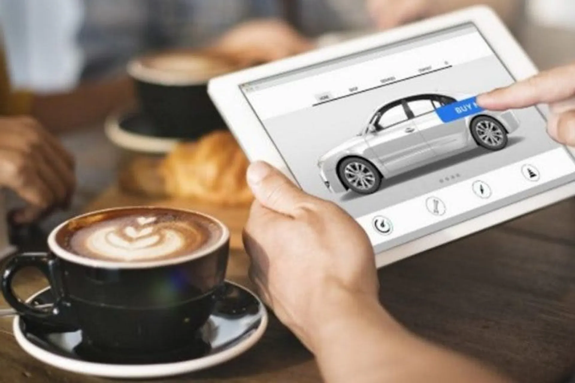 person's finger on an ipad screen with a cup of coffee on the table