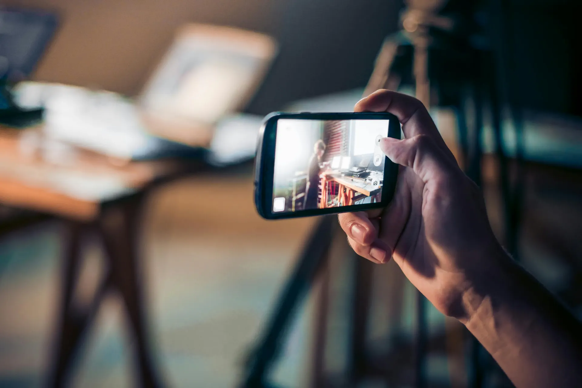 person holding mobile phone while recording a video