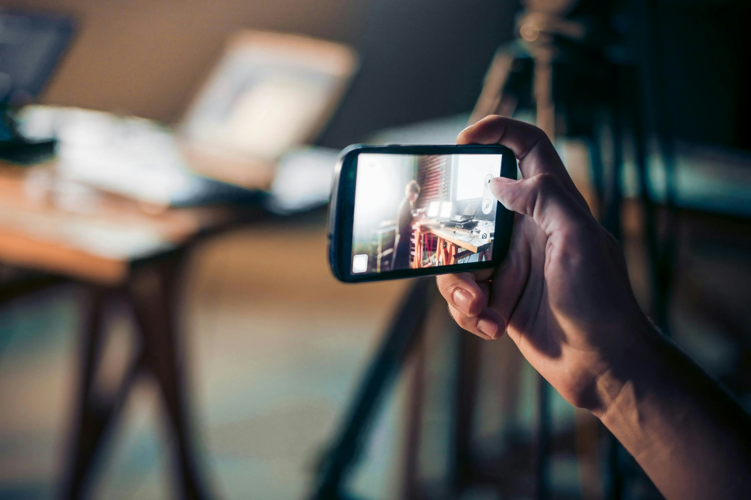 person holding mobile phone while recording a video