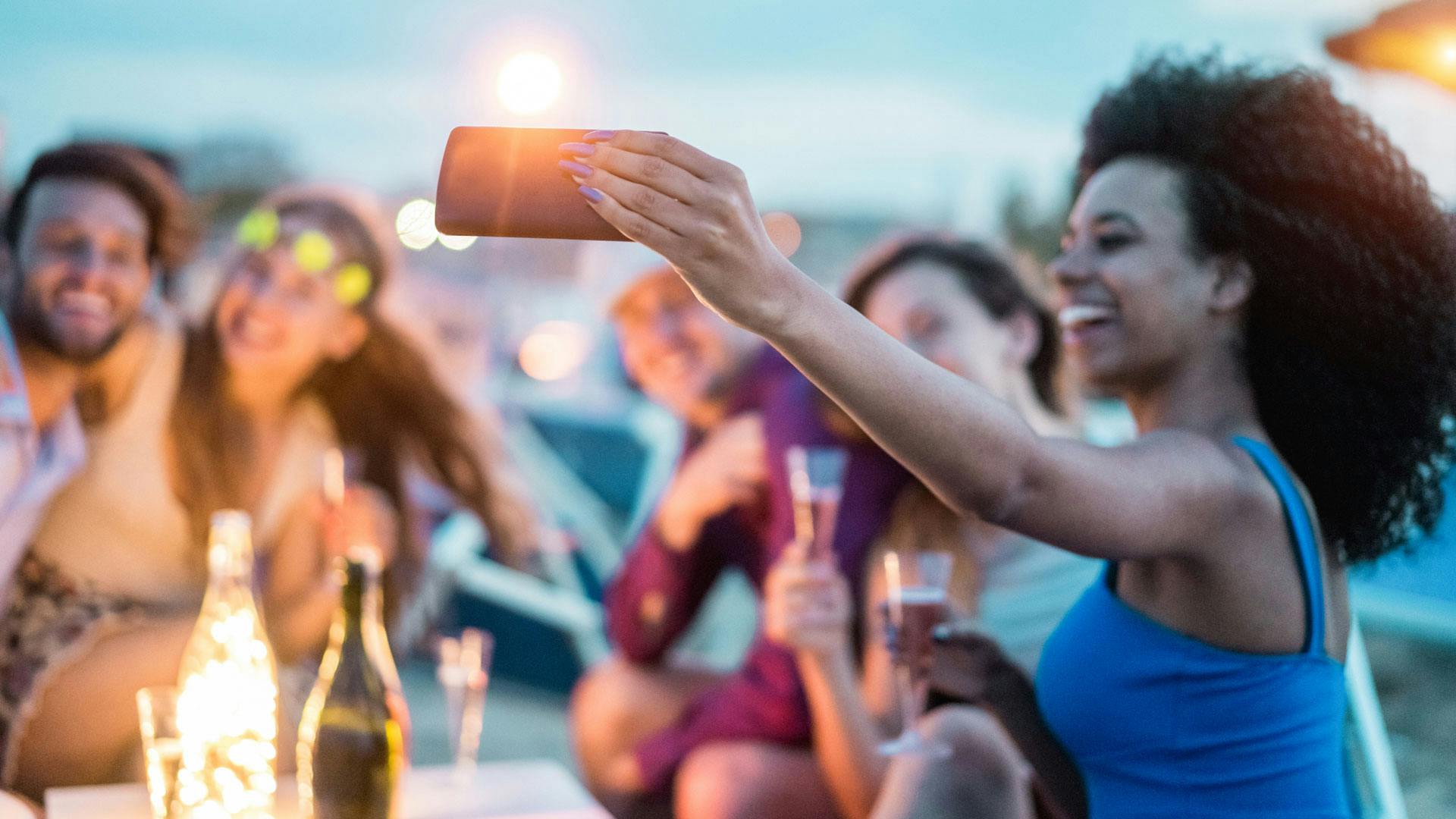 Photo of women at an outdoor party taking a selfie