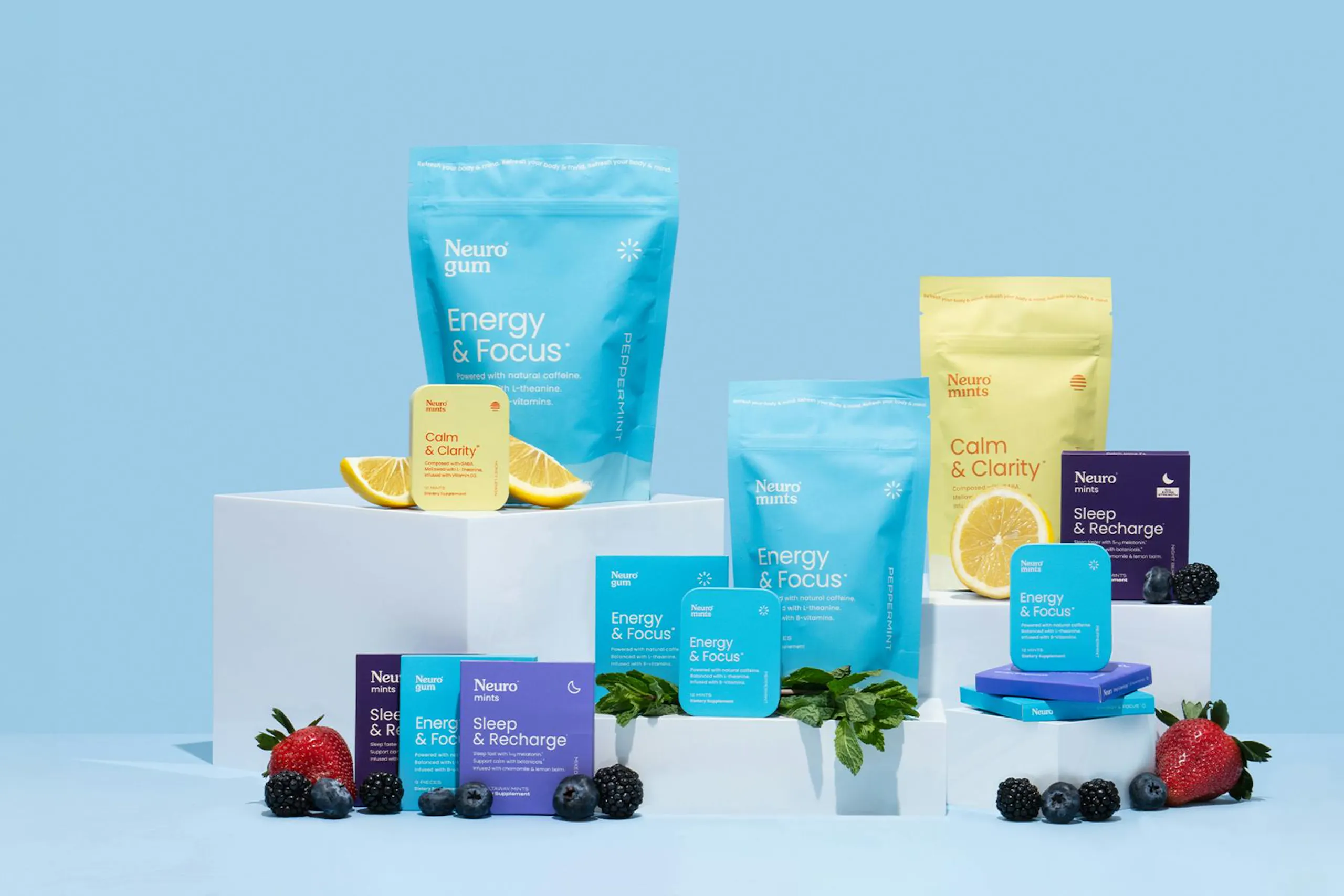 A photo of Neuro's lines of functional gums and mints with pieces of fruit against a blue background