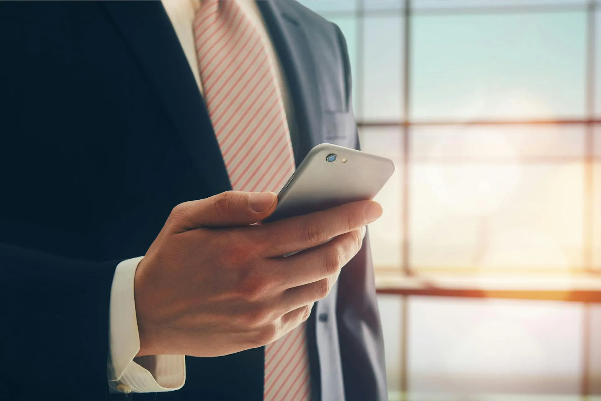 Photo of a business man holding a smartphone