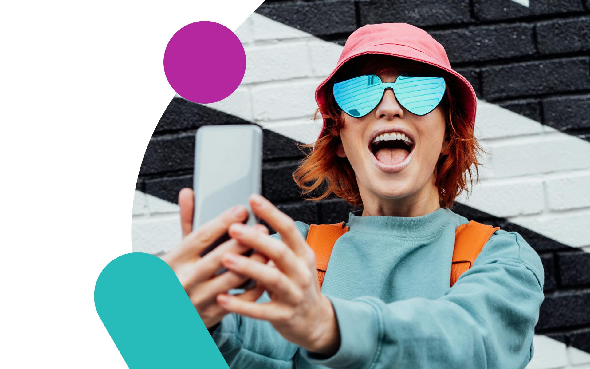 Image showing a young influencer in front of a black and white brick wall, holding a phone. Ultimate guide to influencer marketing 