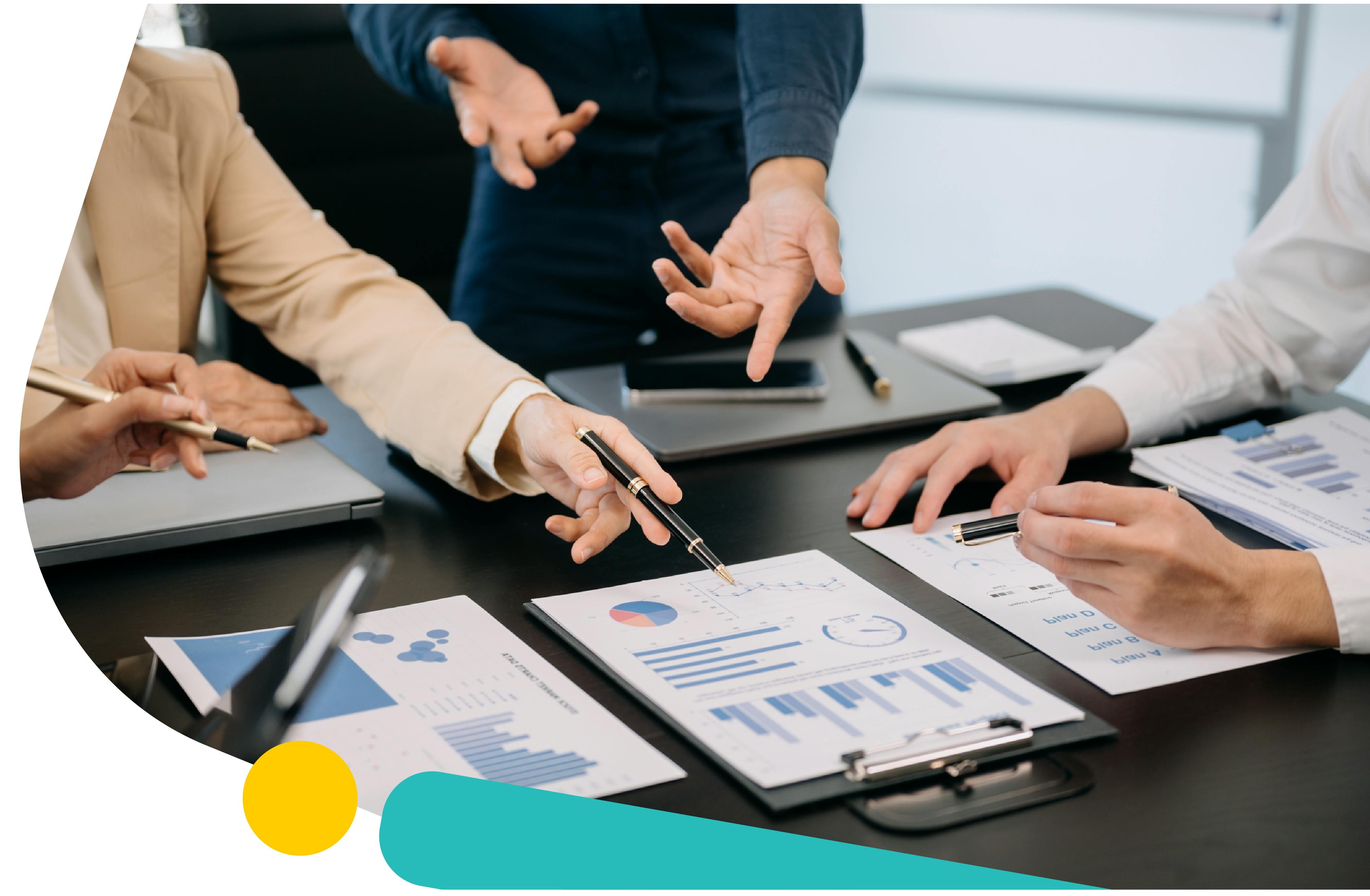A group of three people in a meeting looking at several different graphs. Social Listening for Benchmarking Guide