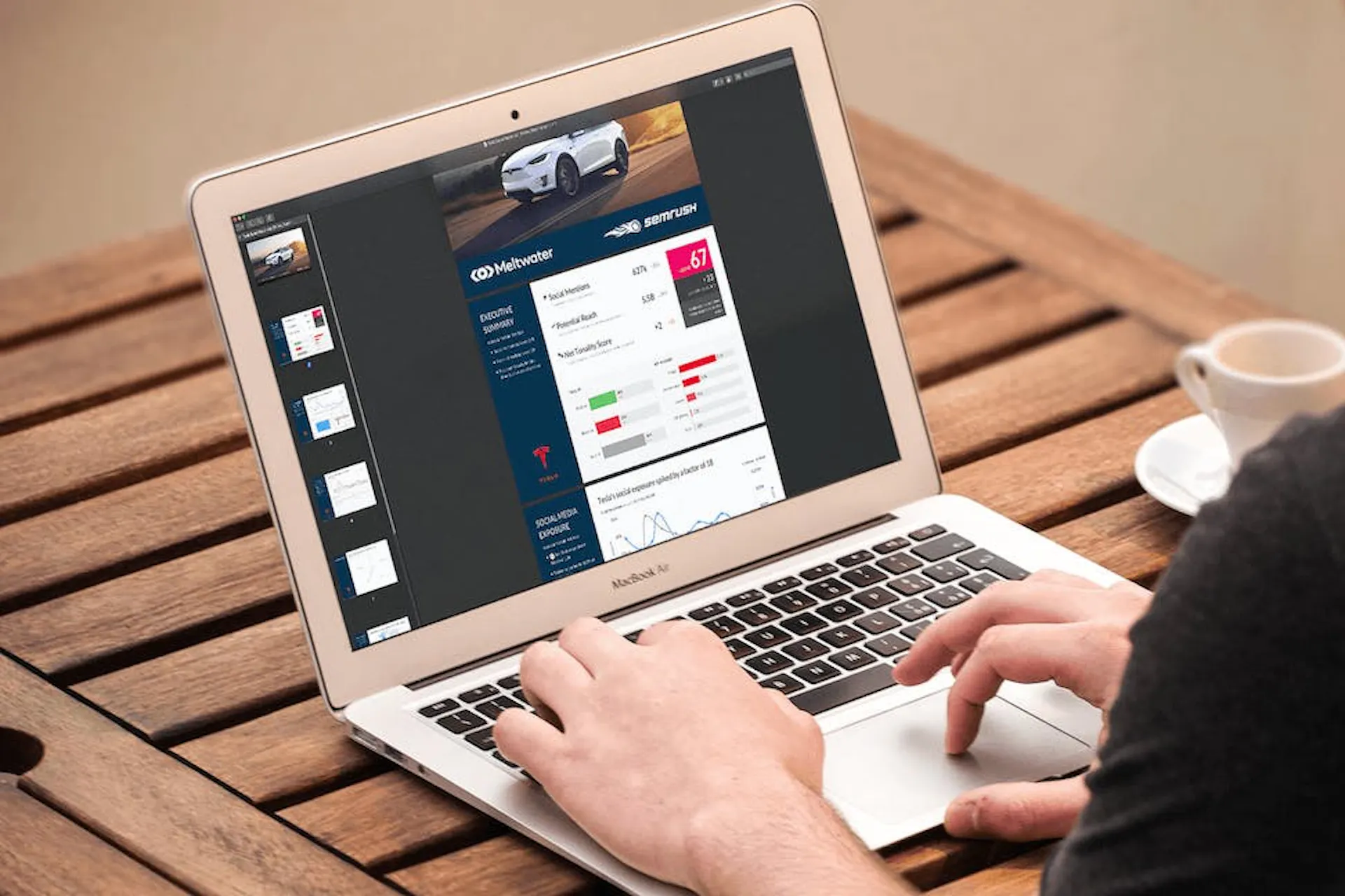 Man sieht einen Mann an seinem Laptop arbeiten. Dabei scrollt er durch den Automobil Branchenreport von Meltwater und SEMrush