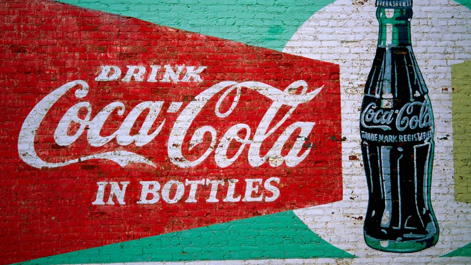 Coca Cola Flasche und Logo auf einer Wand gesprayed