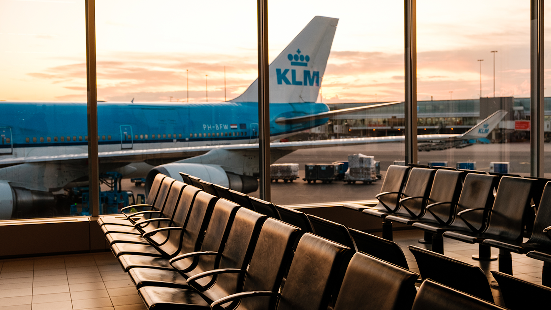 Photo of seats at an airport with a KLM plane in the background
