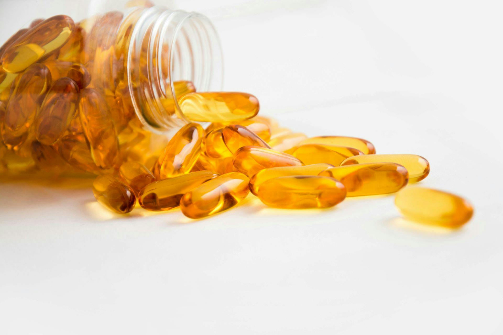An open jar of health supplement capsules. 