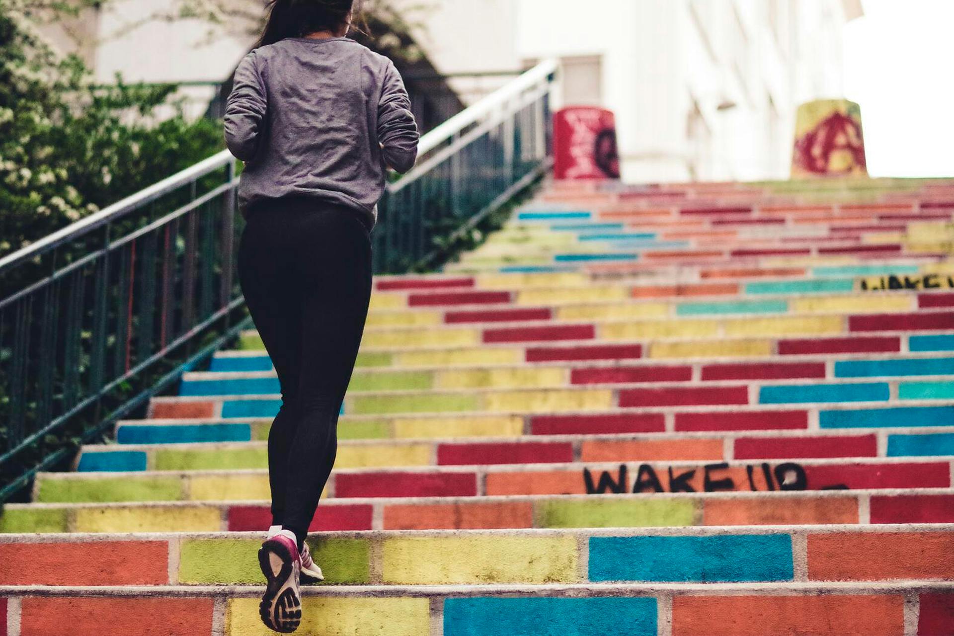 A jogger is walking up colorful stairs