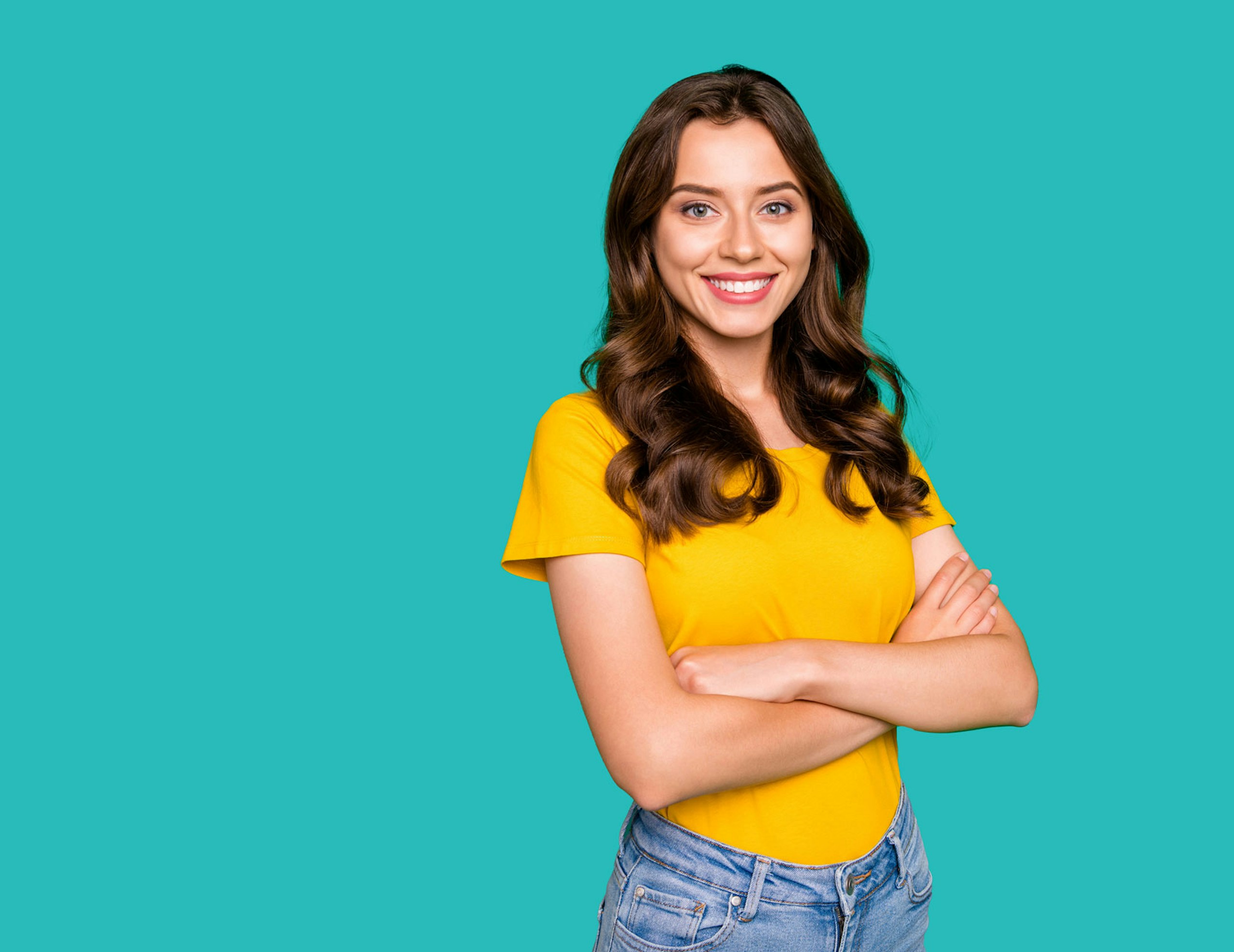 A woman standing in front of a teal background