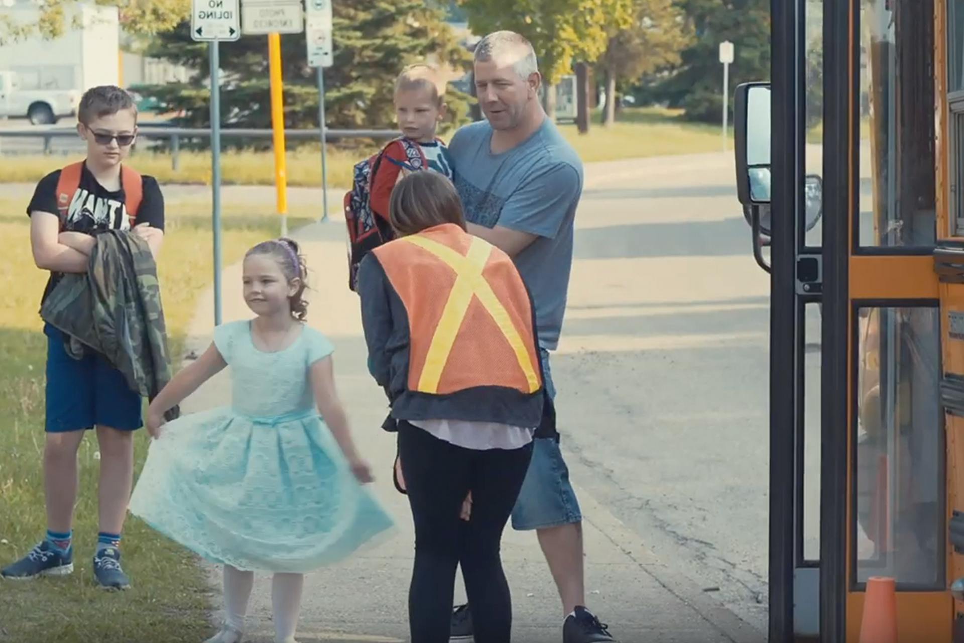 Photo of a young girl getting out of the school bus