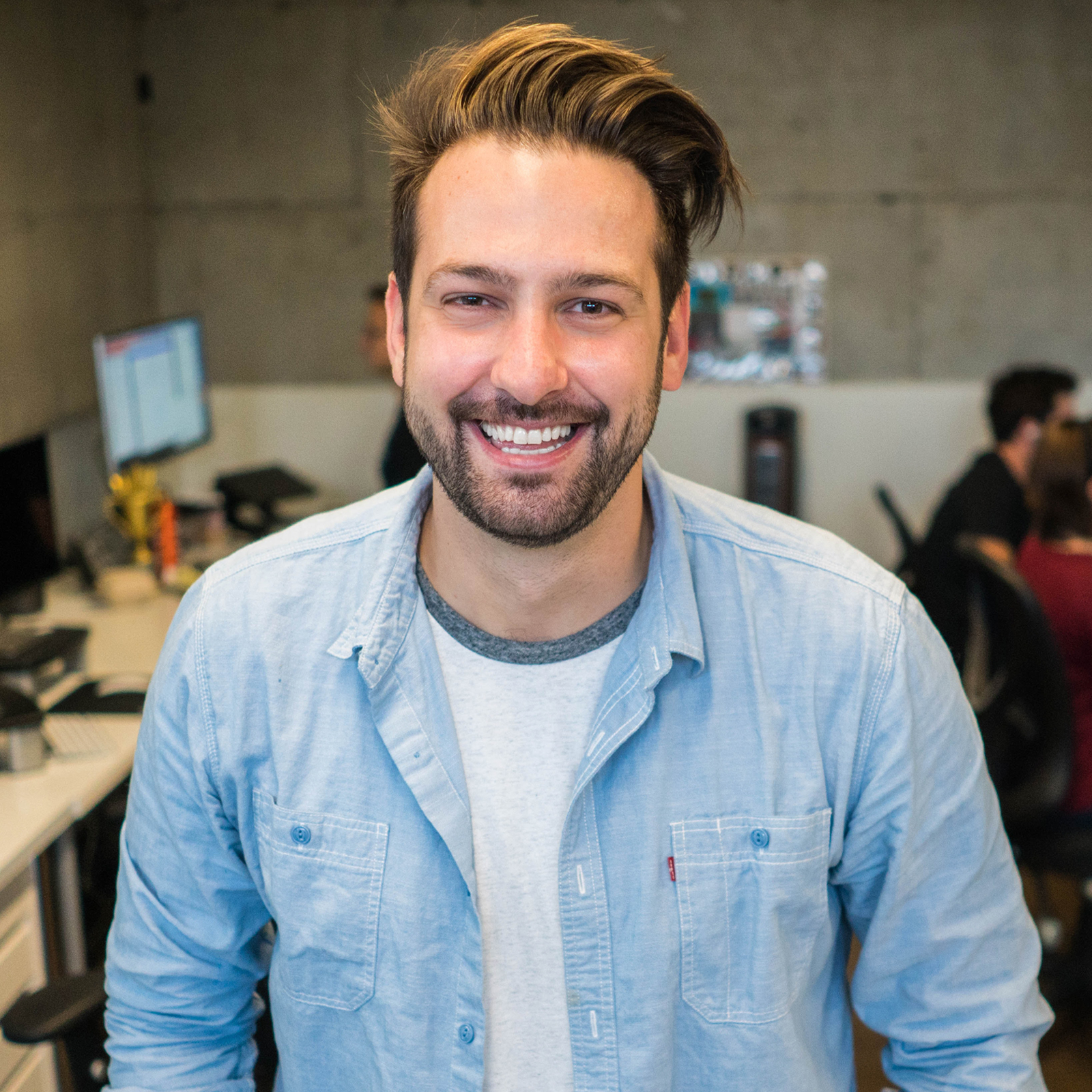 a smiling man standing in an office space