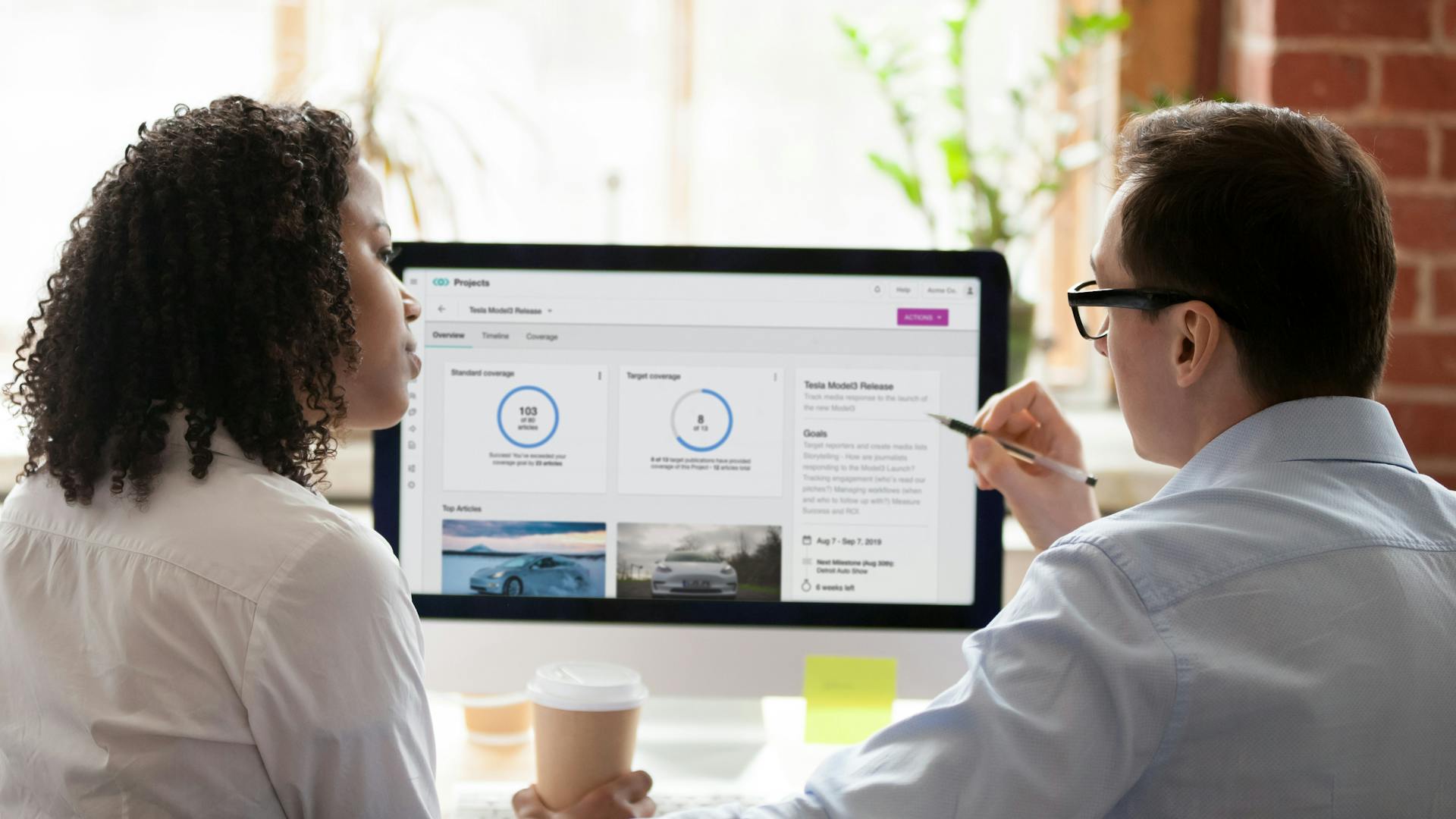 two people discussing in front of computer