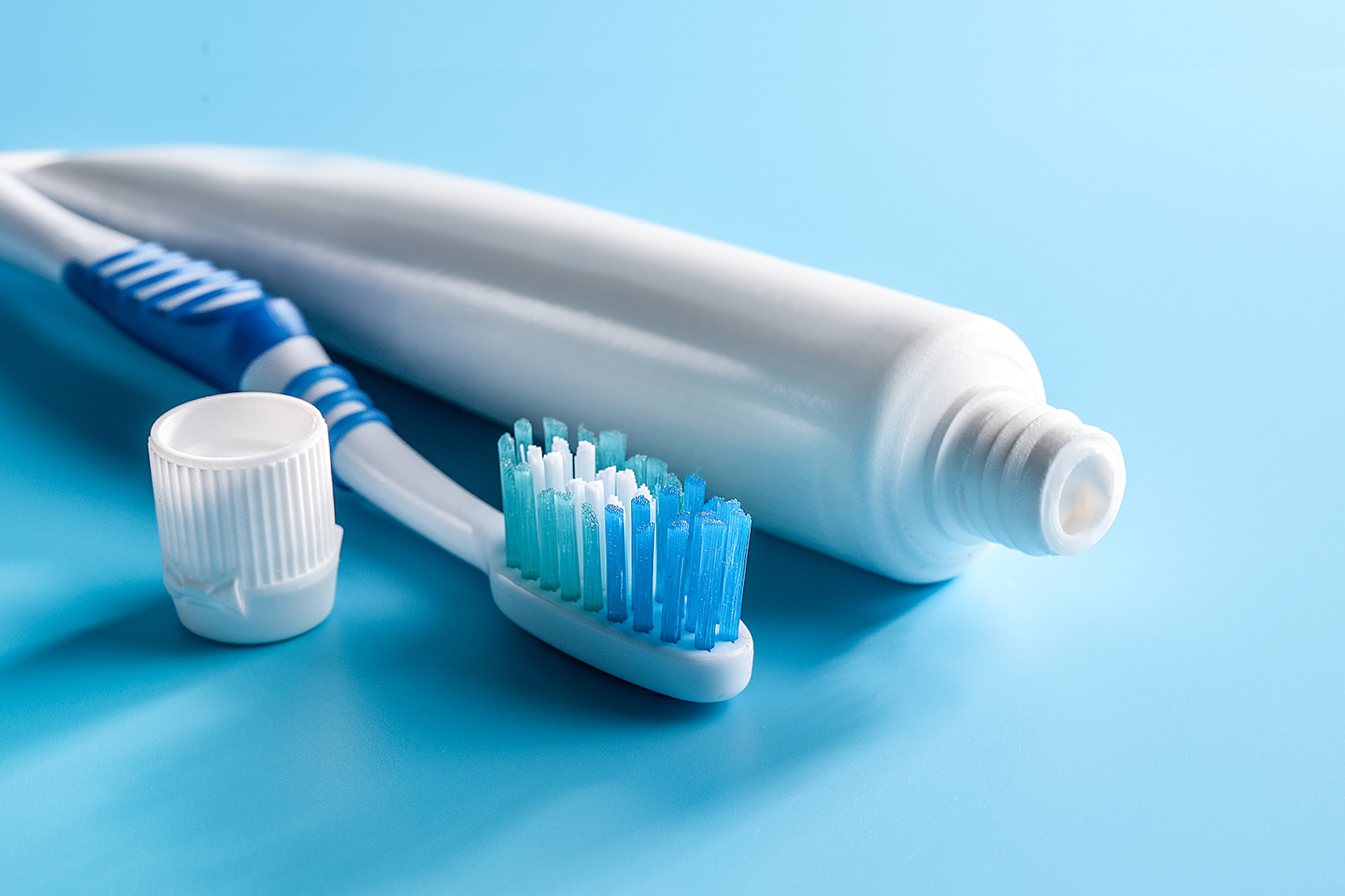 Une image d'une brosse à dent et tube de dentifrice sur une fond bleu