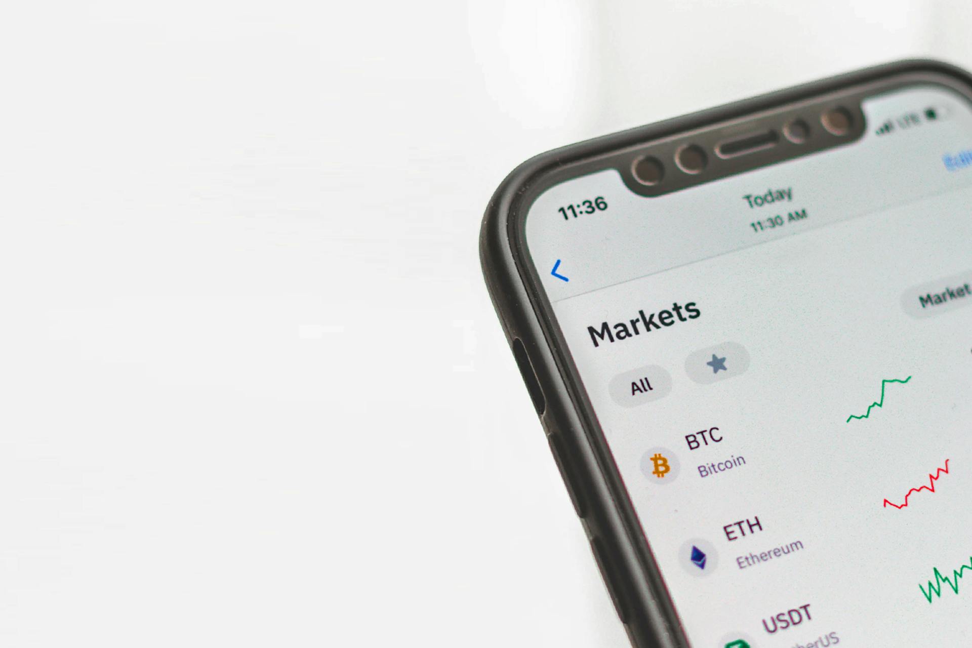 Photographie d'un téléphone portable qui montre une application détaillant les performances du marché de diverses cryptomonnaies. 