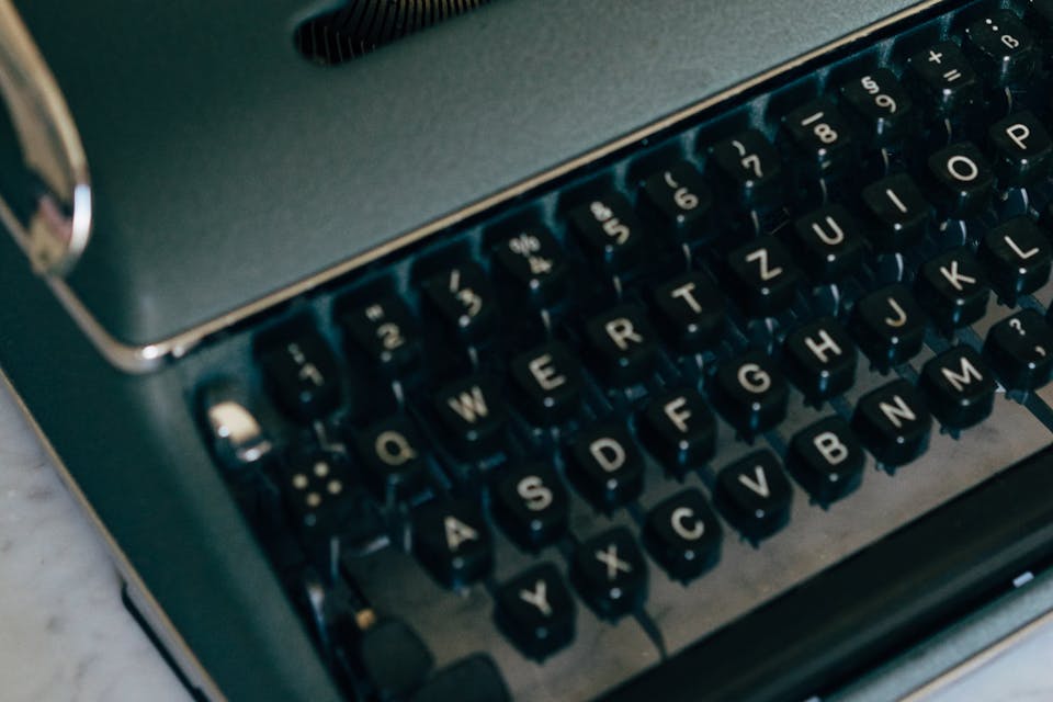 black olympia typewriter with fake news written on white paper