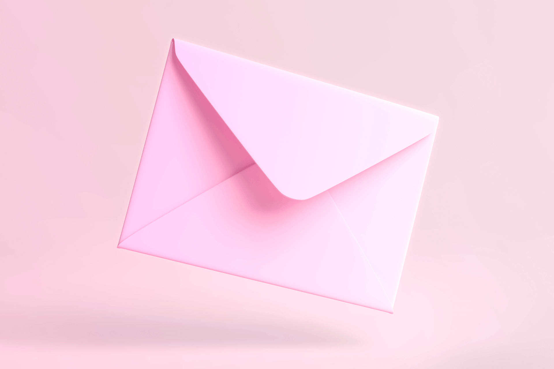 Slightly open pink envelope on light pink background. Header image for blog post: why you need an internal newsletter