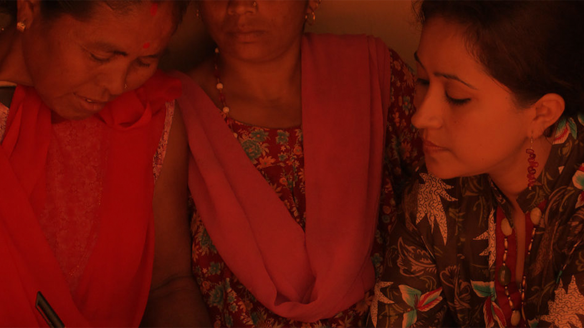 Foto in dunkler Stimmung mit Rotstich von indischen jungen Frauen