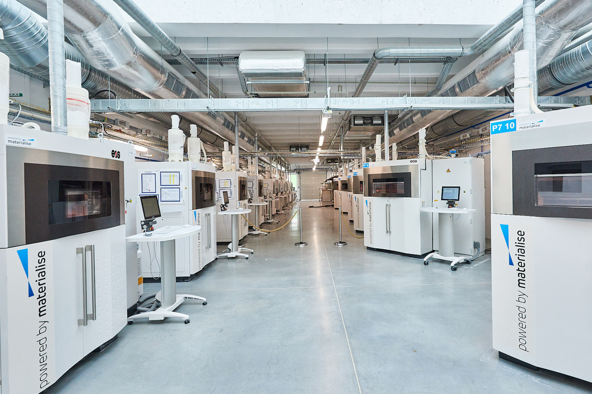 A lab full of 3D printers labelled "powered by materialise" in an image for a Meltwater customer story.