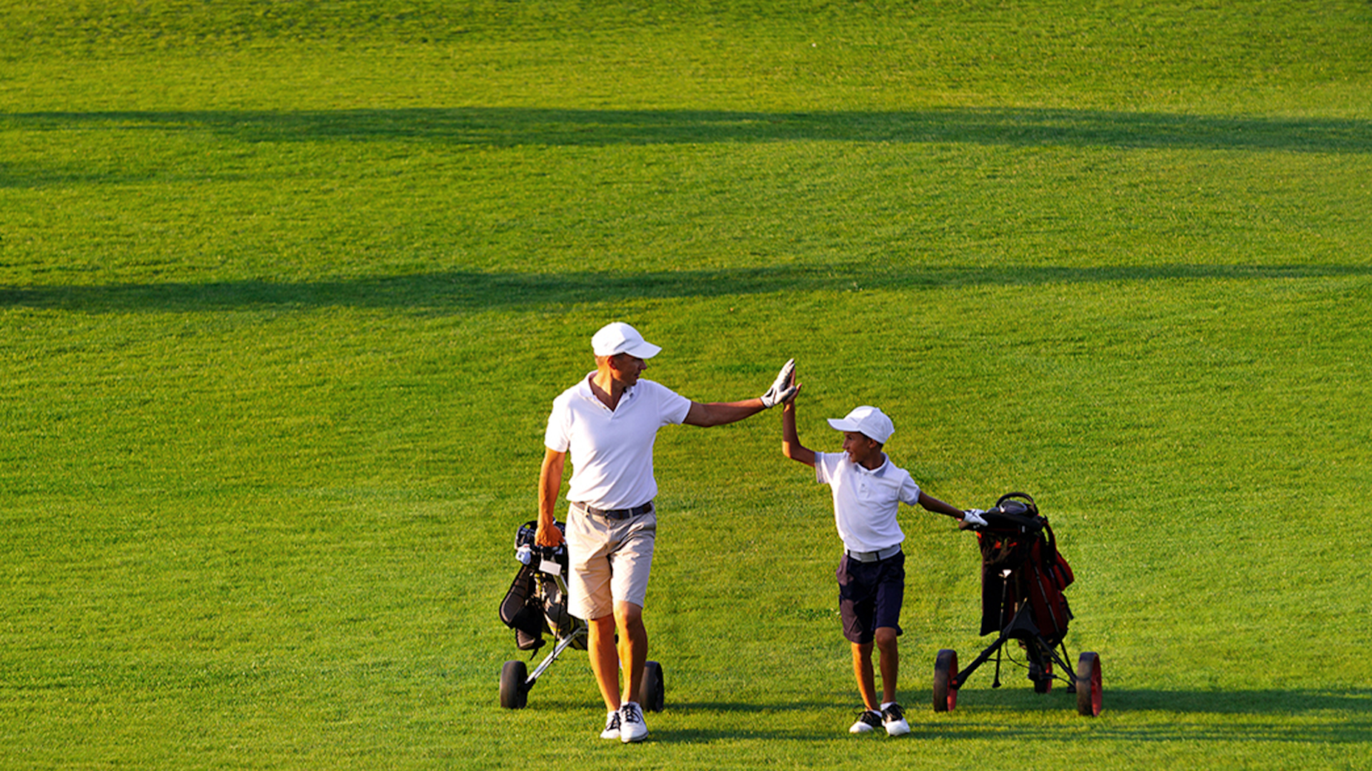 Photo of a father and his son on the golf court