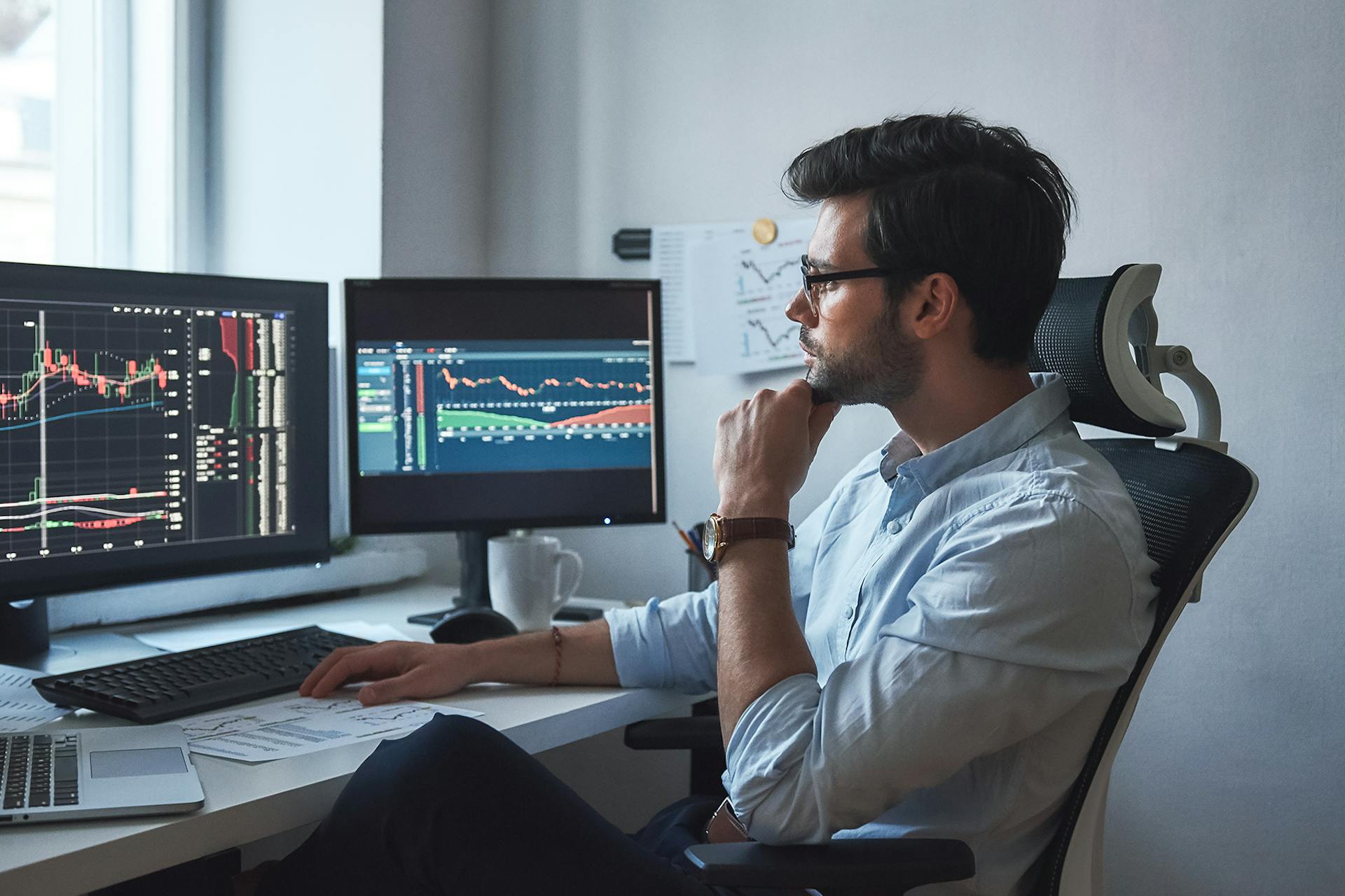 A person sits in an office chair in front of two monitors showing analytics charts for a Meltwater customer story about Luscid.