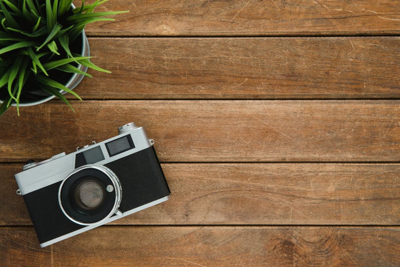 A vintage camera resting on a wooden table.