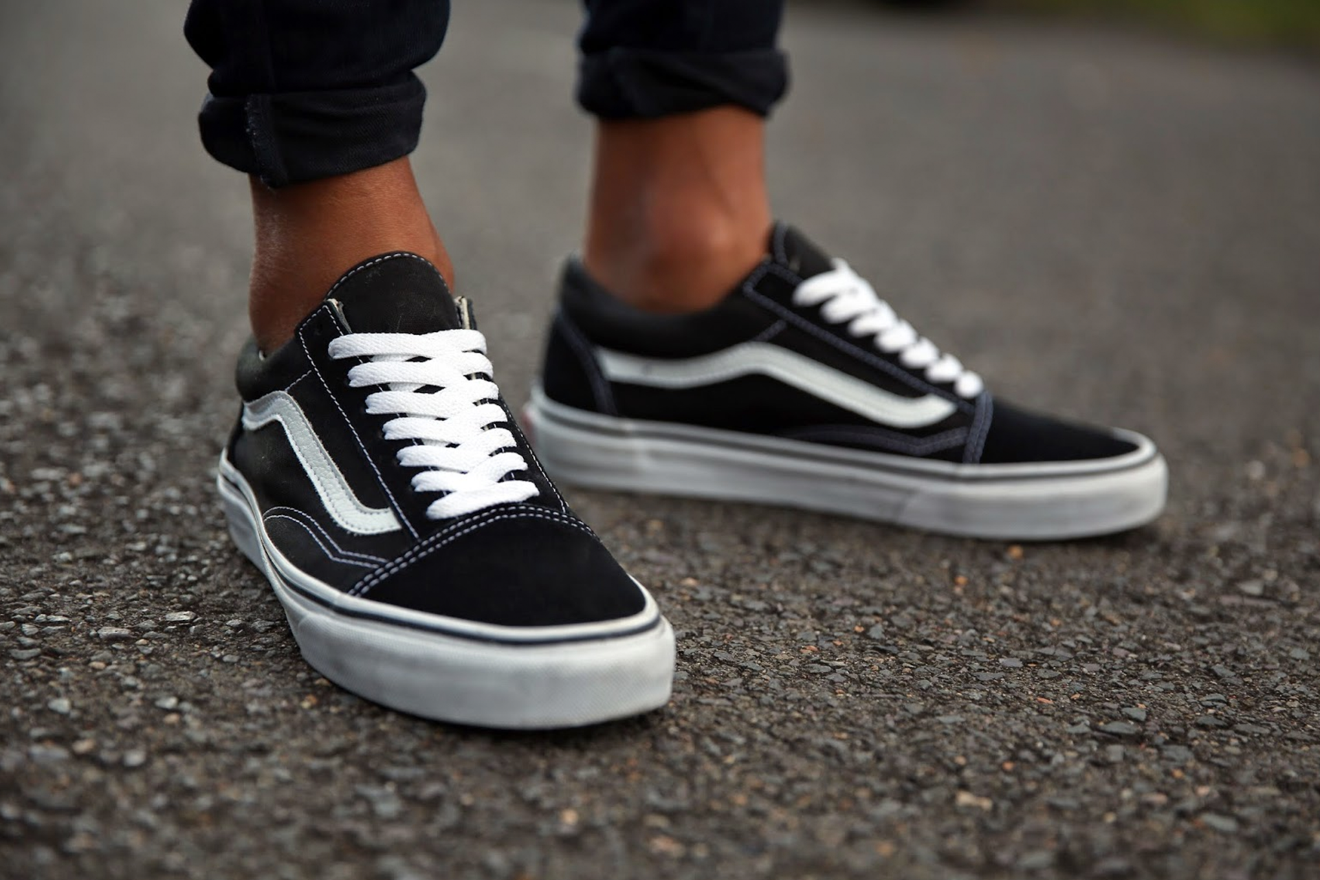 Feet wearing black Vans