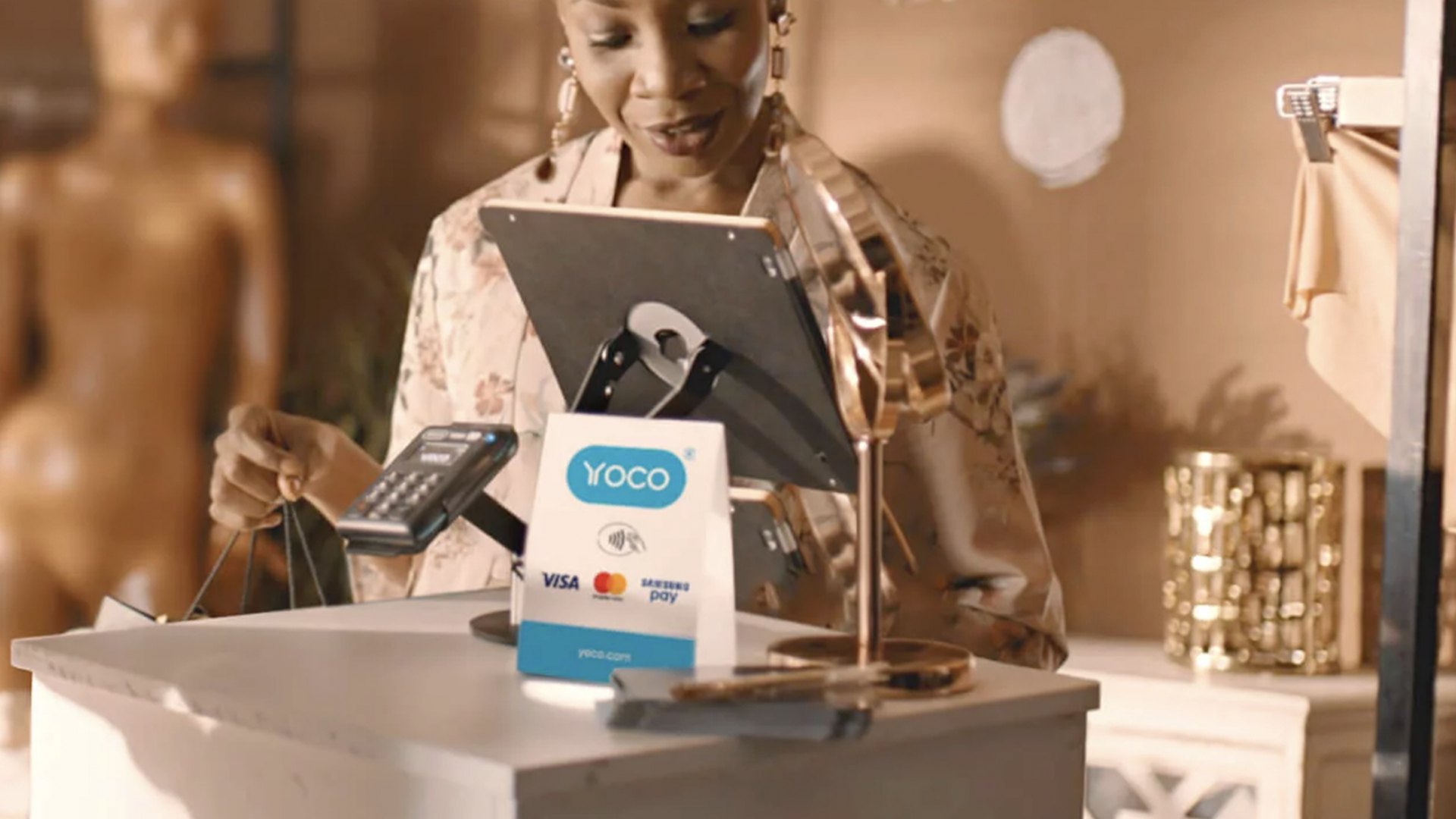 Photo of a woman in a shop using Yoco system to pay