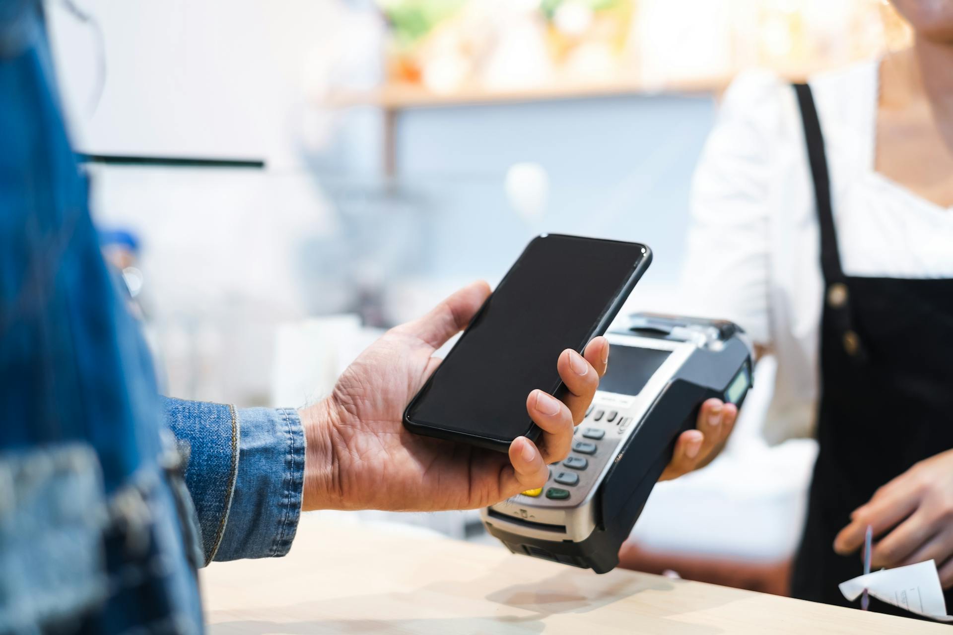 Photo of someone paying in a shop with their smartphone