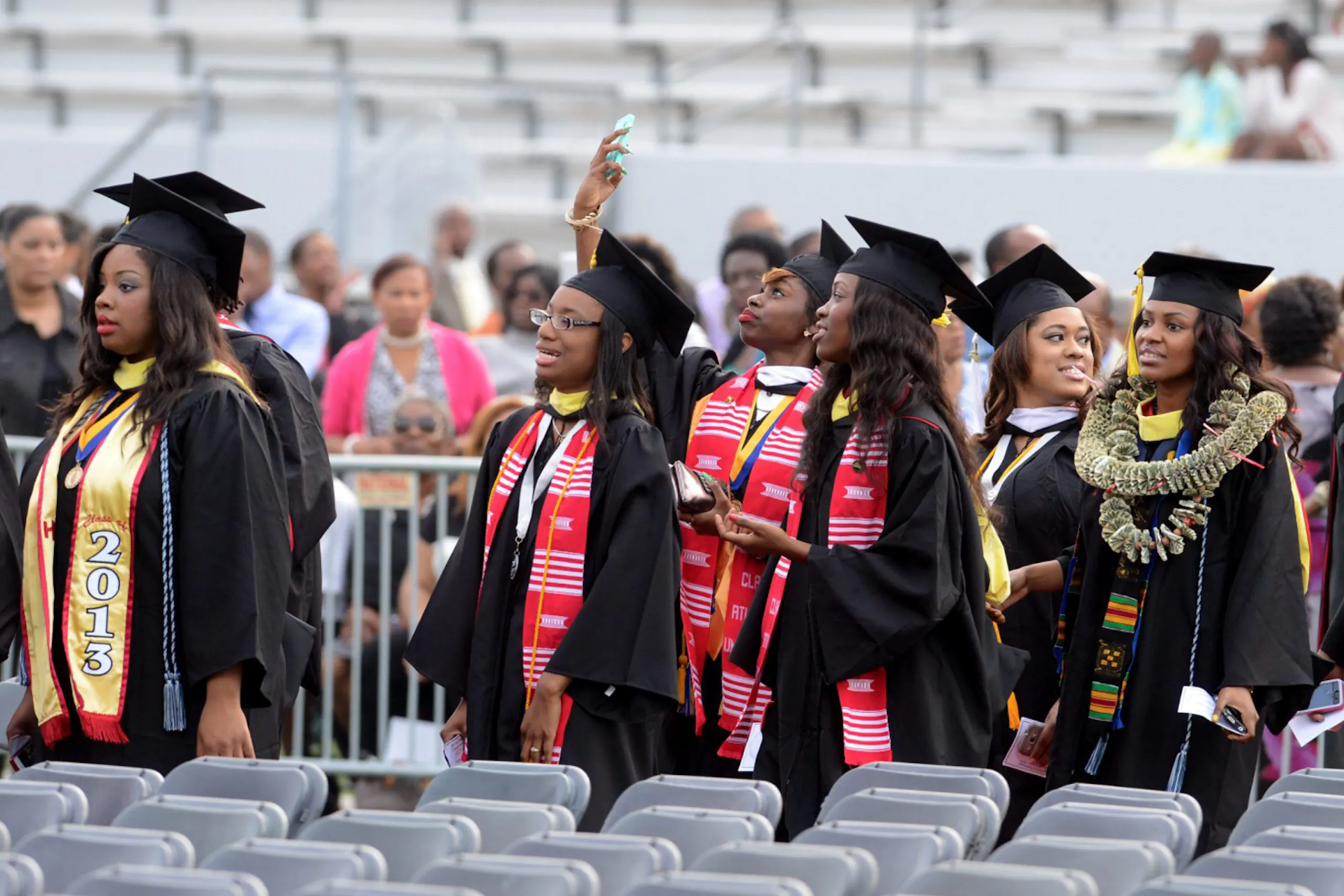 An image of African-American students in graduation robes walking between aisles of chairs for a Meltwater customer story about UNCF.