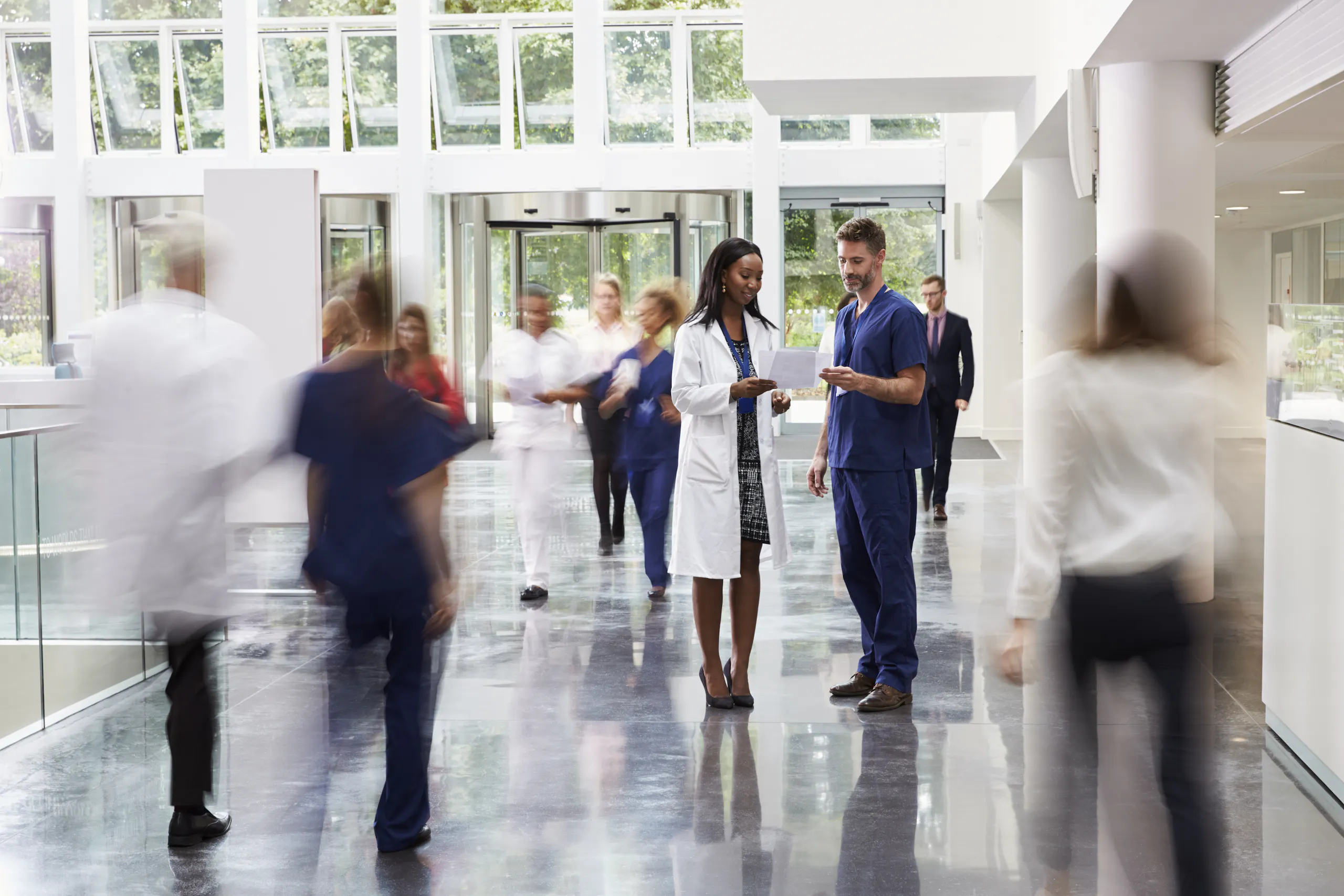 Menschen sind in Bewegung und sprechen miteinander im Krankenhaus