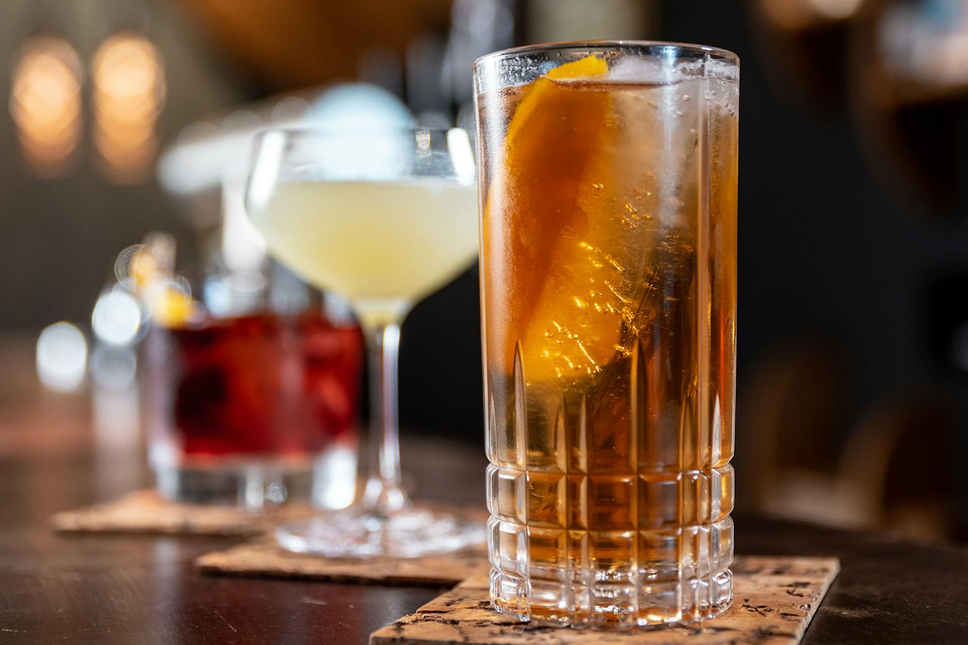 An image of three cocktails displayed on a bar counter