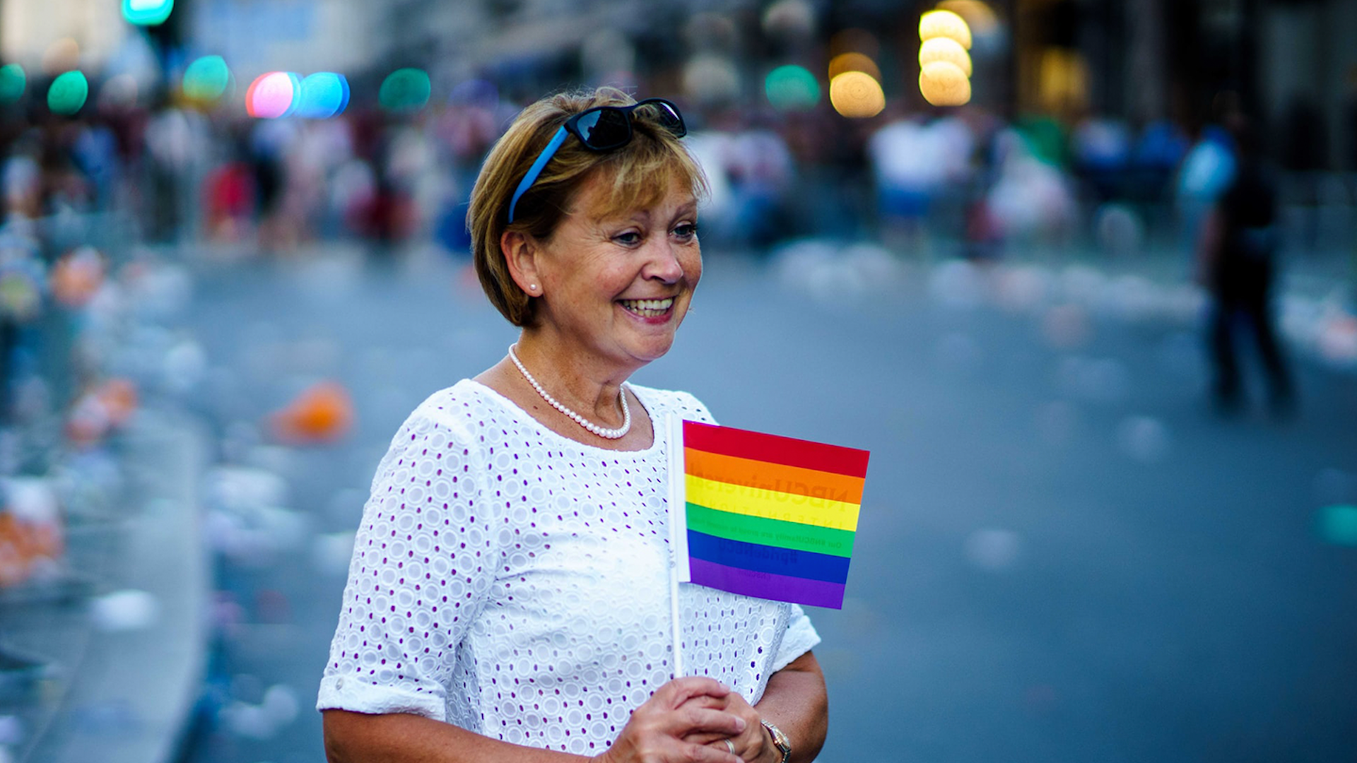 Photo of a woman holding the rainbow flag