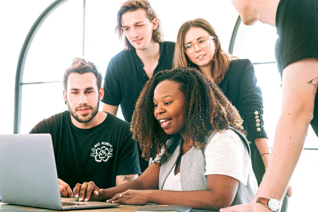 People in a marketing agency sitting around a computer.
