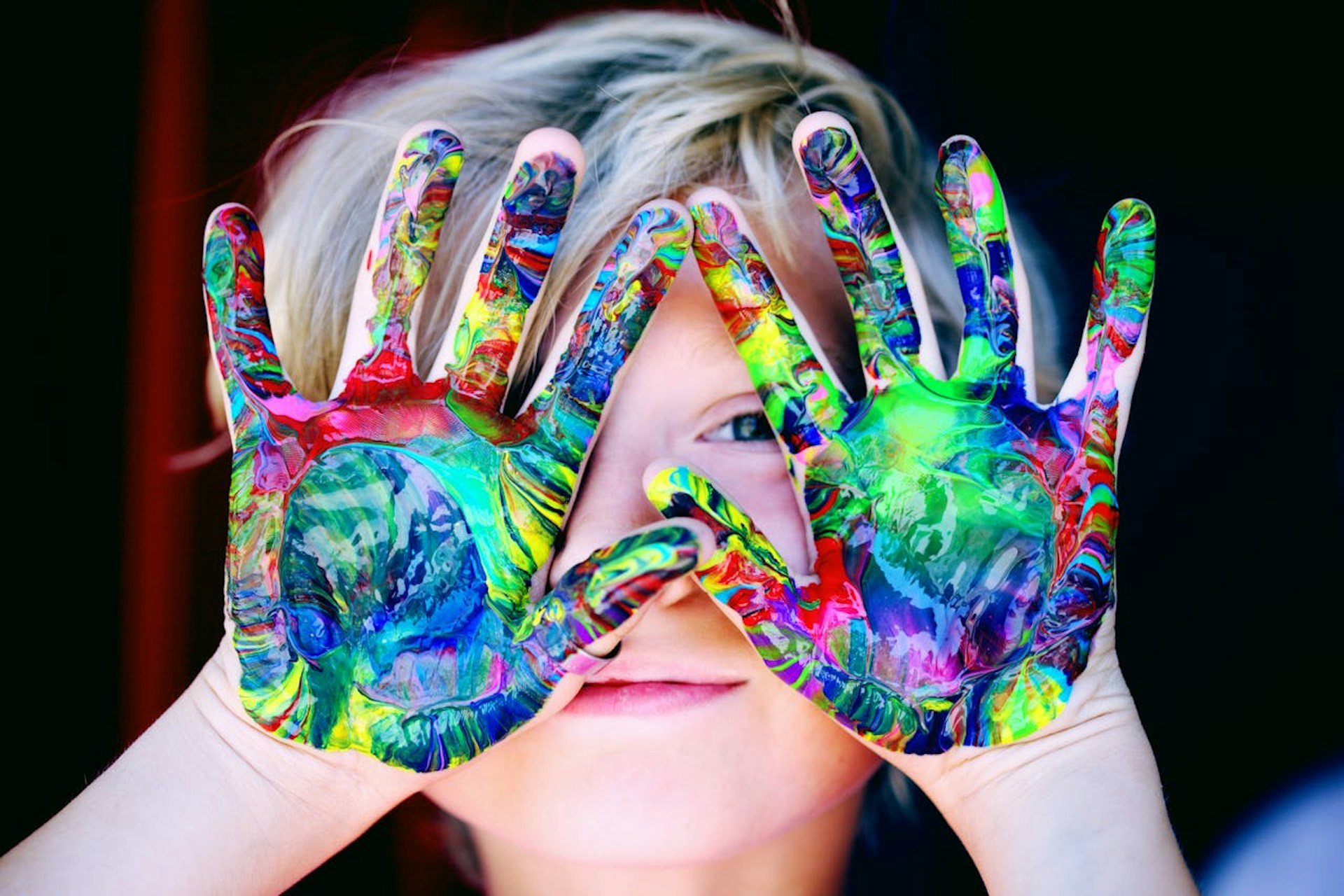 A child with paint on their hands. 