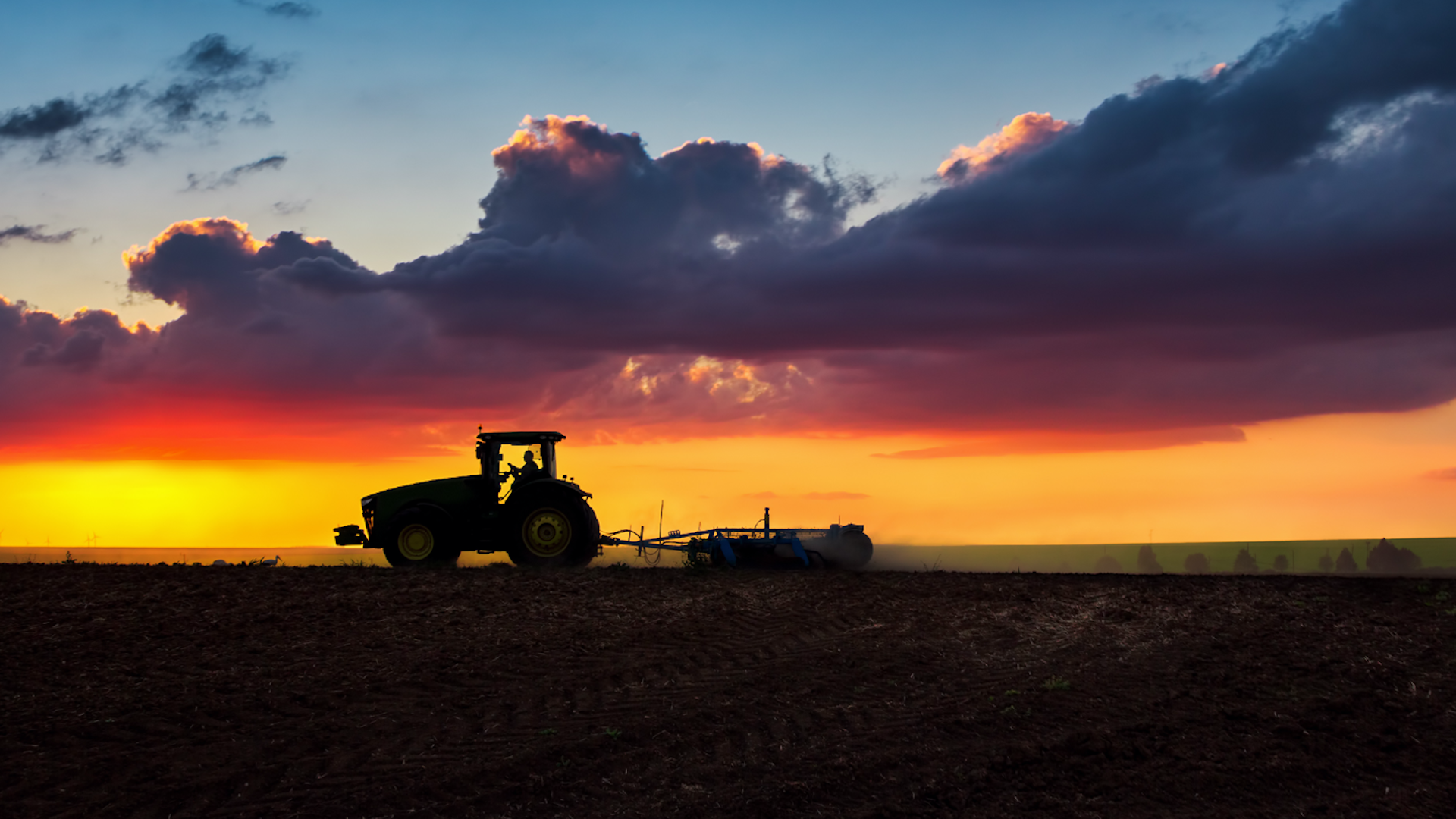 Photo of a farming machine in the sunset