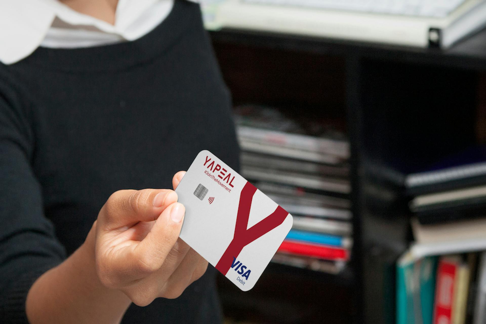 Foto Frau hält YAPEAL Kreditkarte Visa in die Kamera