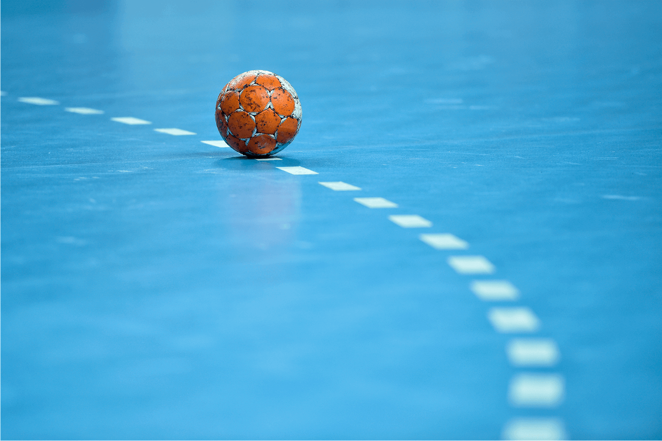 Foto Handball liegt auf blauem Handballfeld