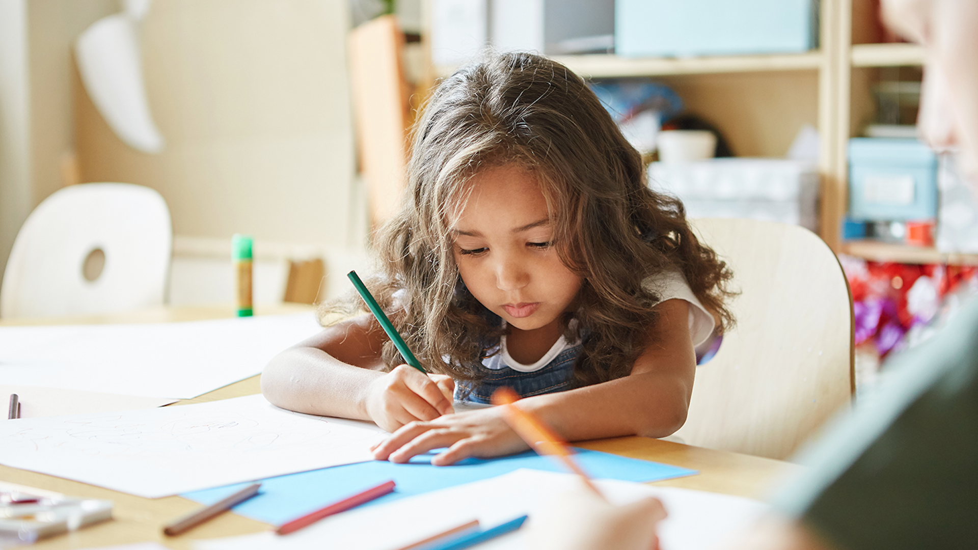 photo of a young girl drawing at her desk