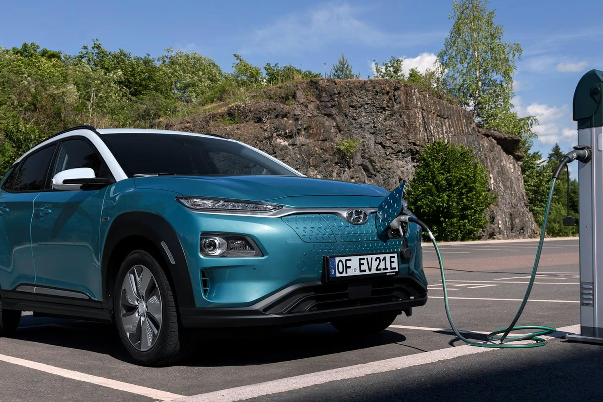 Image of teal electric Hyundai car at a charging station