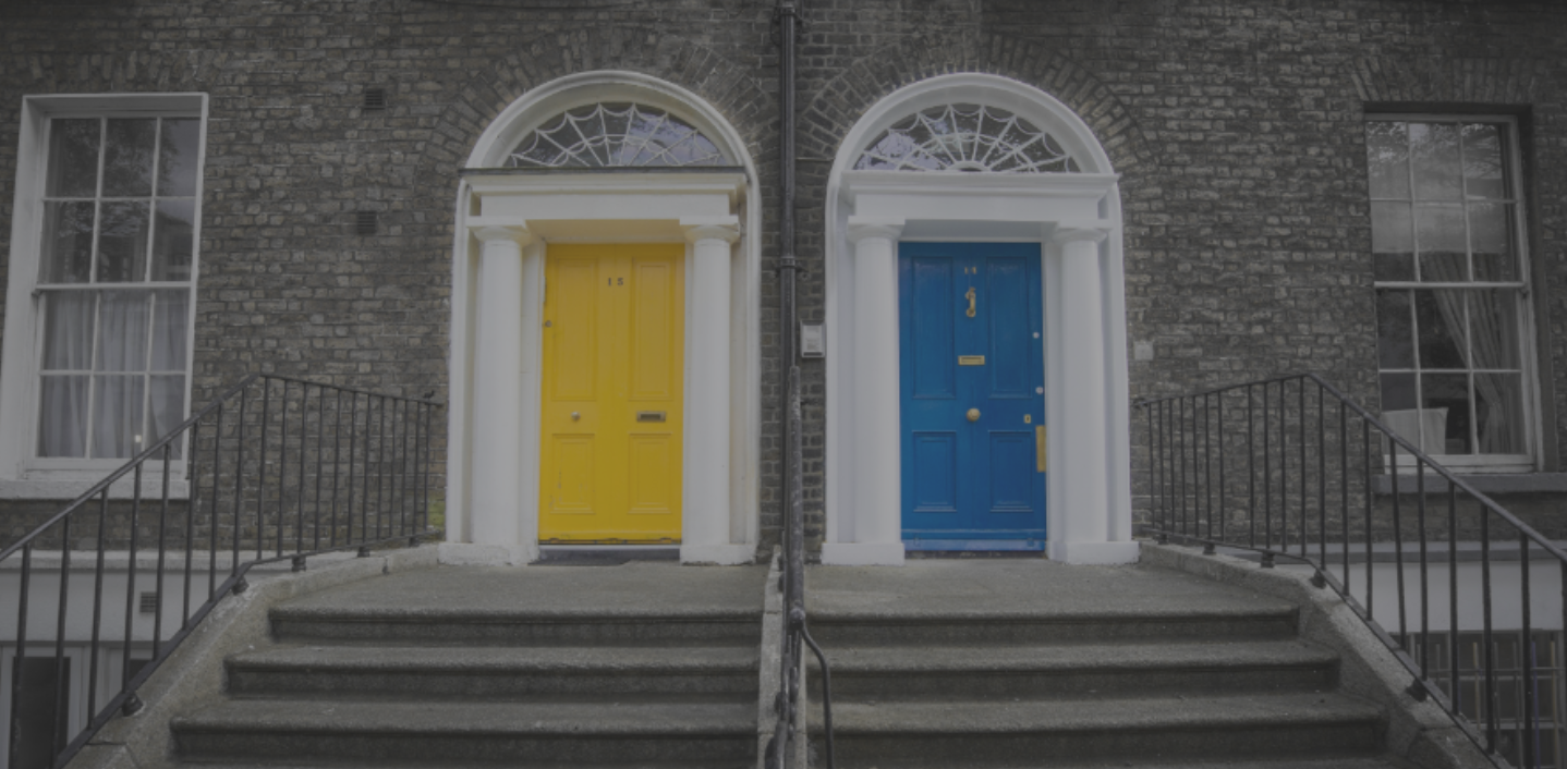 Two doors with grey steps leading up to them. One door is yellow, the other is blue.