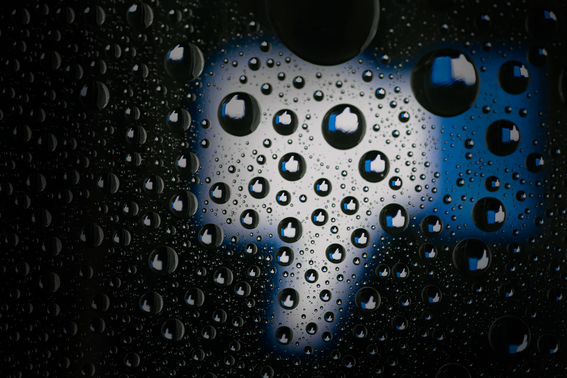 Photo of rain drops with the Facebook like icon thumbs down in the background