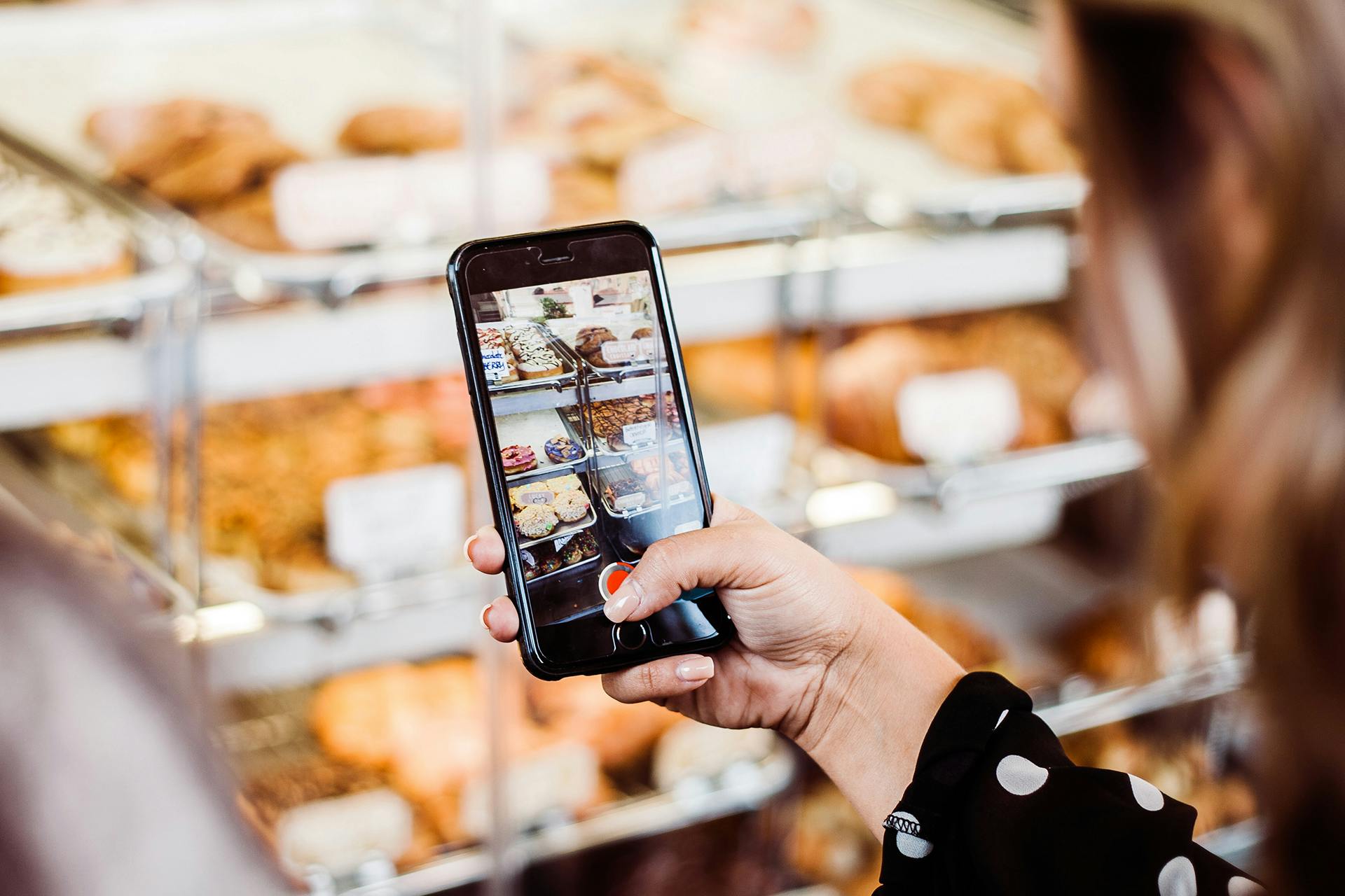 persoon die een telefoon vasthoudt en foto ' s maakt van enkele gebakken lekkernijen